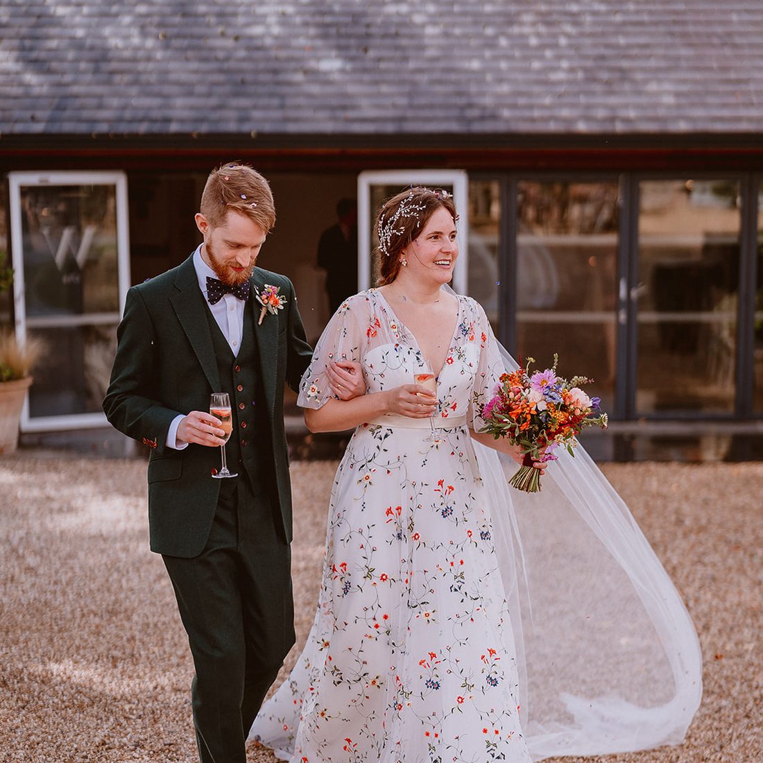 A couple celebrating in an embroidered wedding dress altered at Orhan