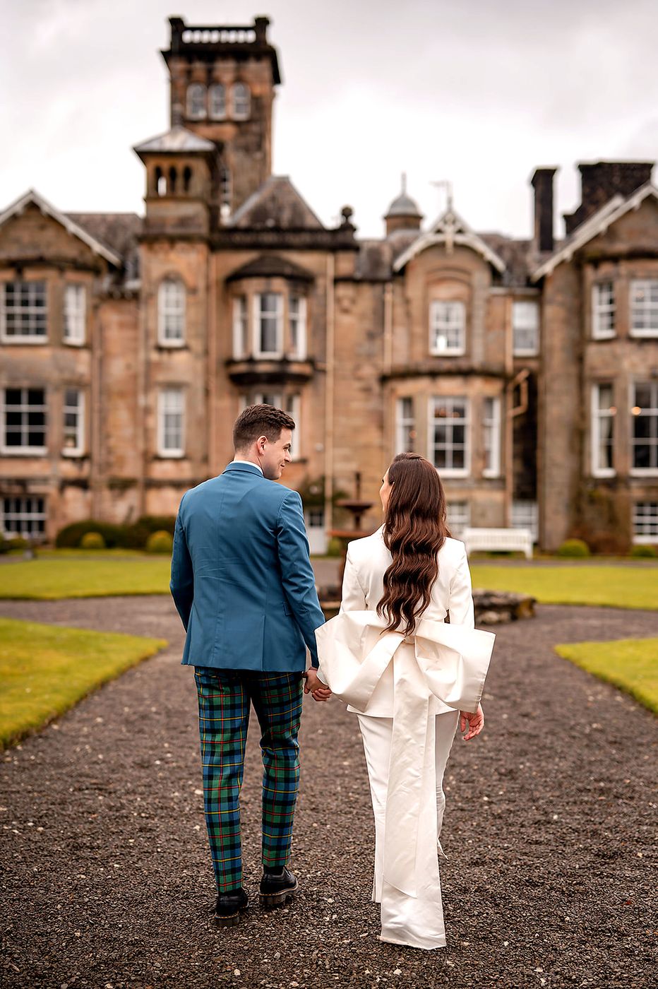 The couple walking towards the house, the suit's bow on show