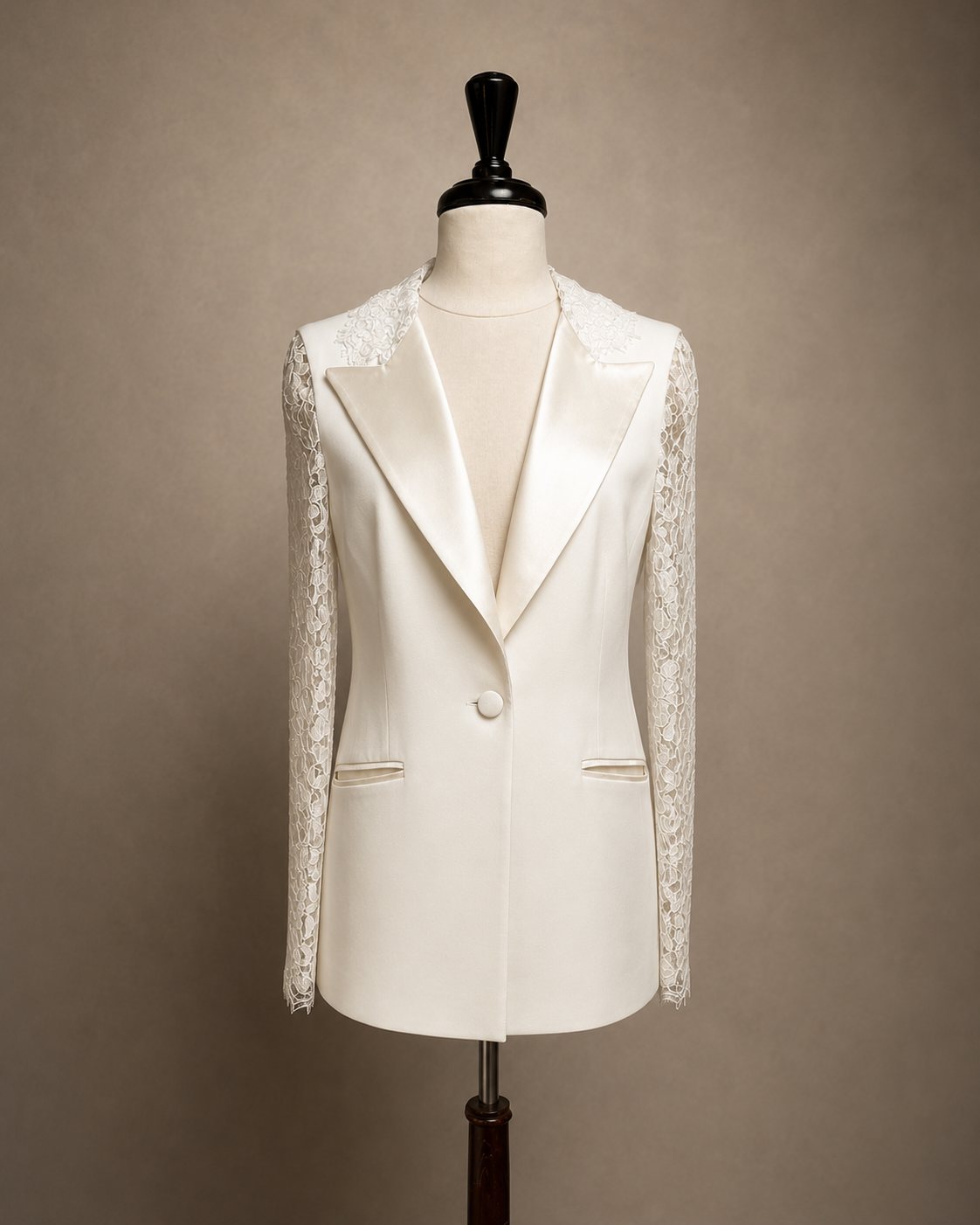 An ivory bridal jacket with lace sleeves on a mannequin