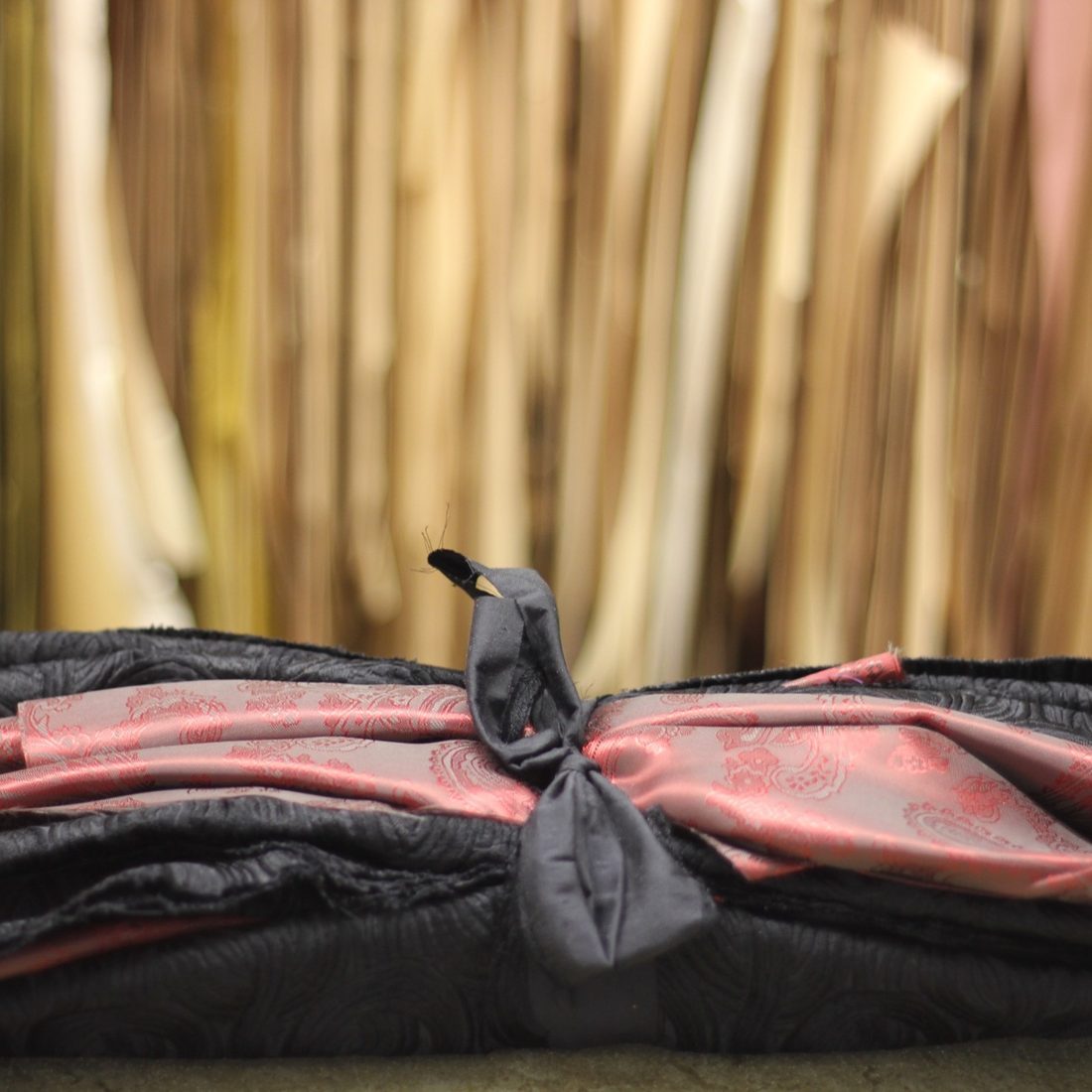 Cut pieces in paisley lining wrapped in black cloth and tied with a bow