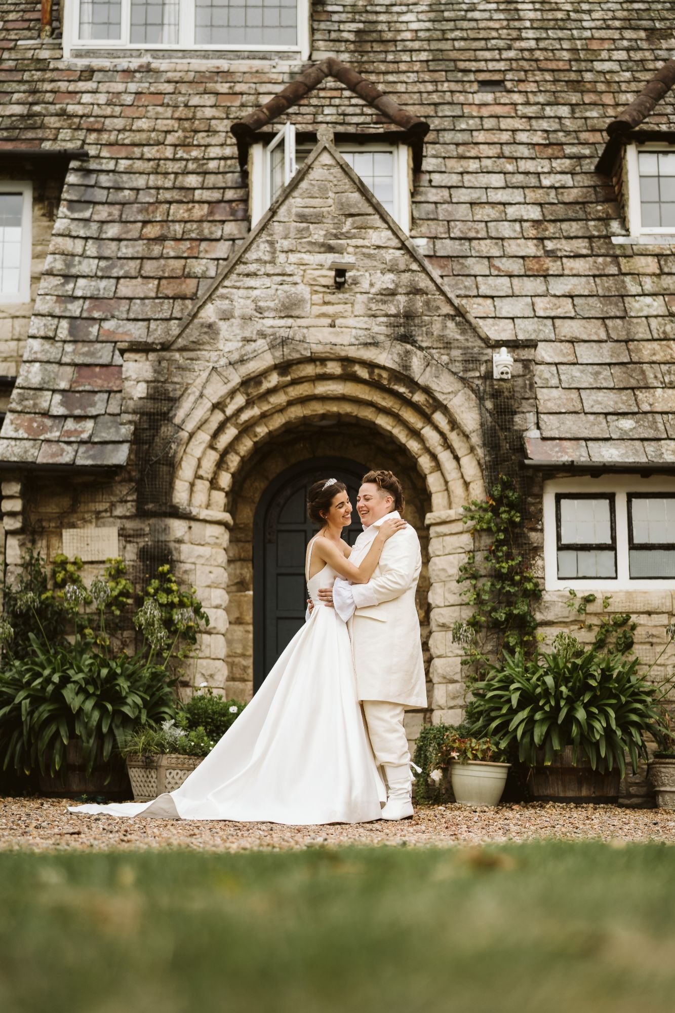 Two brides laughing by a vintage van