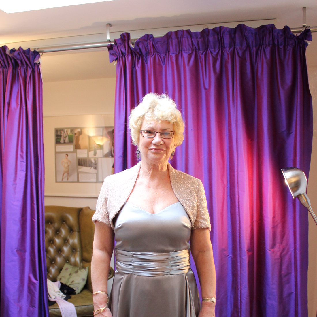 A silver satin gown and beaded bolero at a studio fitting