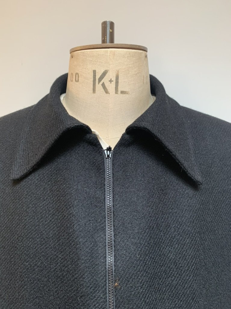 Collar and zip detail on a black twill wool jacket