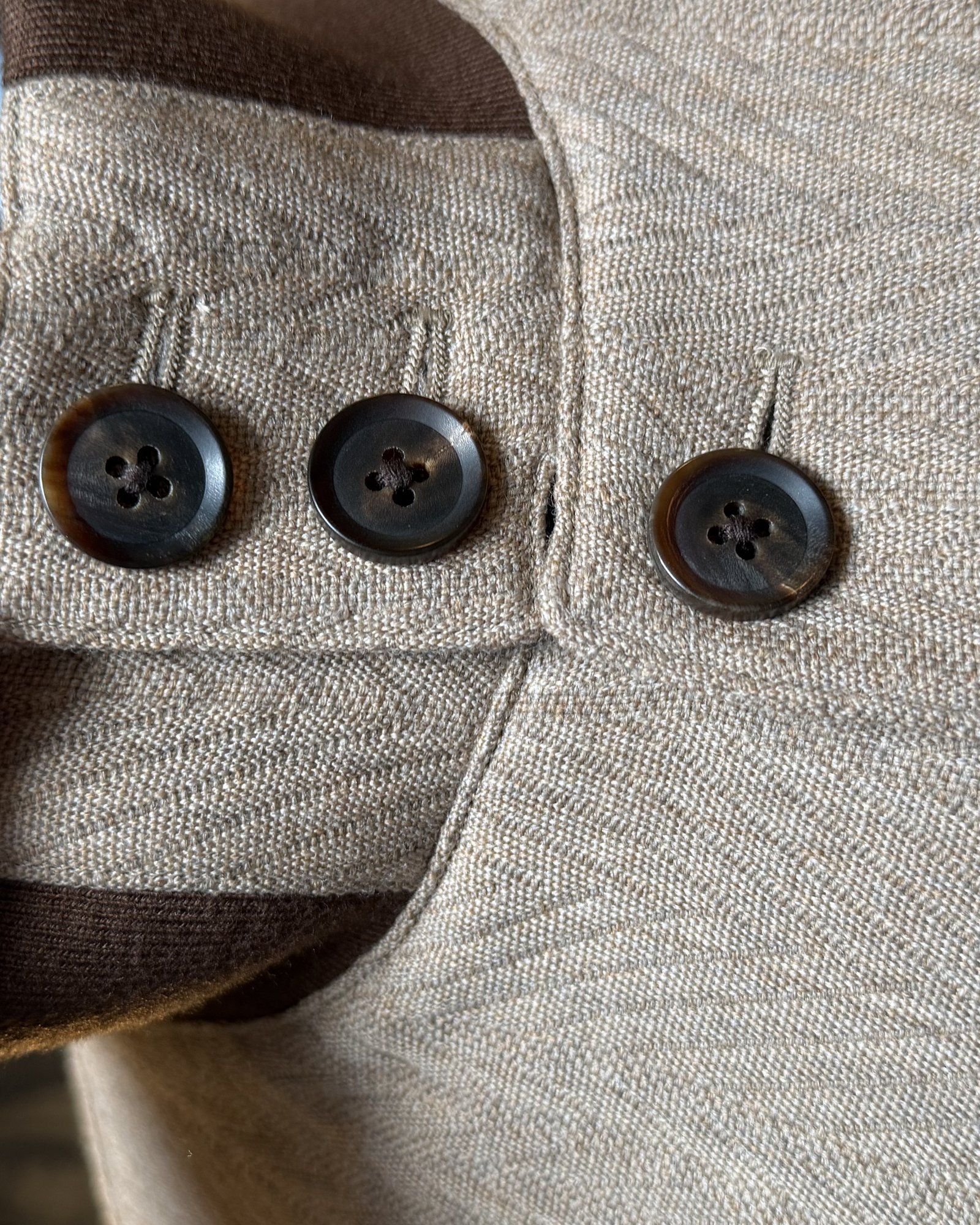 Horn cuff buttons on a cream herringbone casual jacket, checked by hand