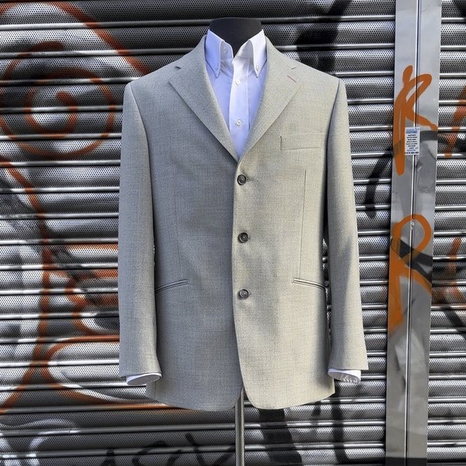 A pale grey jacket on a tailor's stand outside the Shoreditch studio
