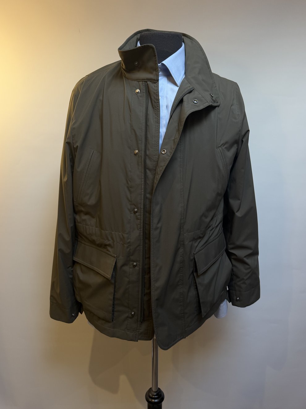 An olive field jacket worn open over a white shirt