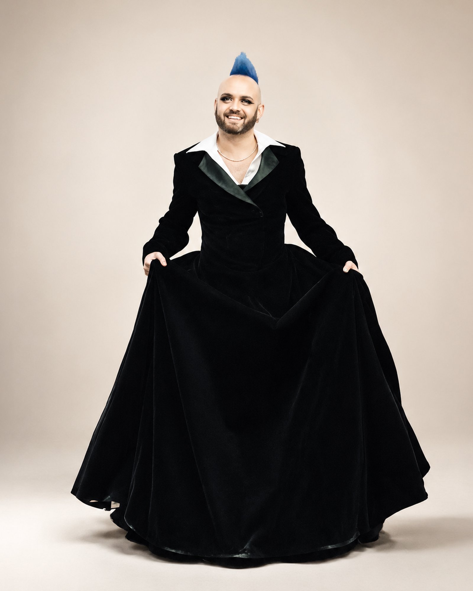 A client with a blue mohawk in a black velvet gown cut with tailored tuxedo lapels