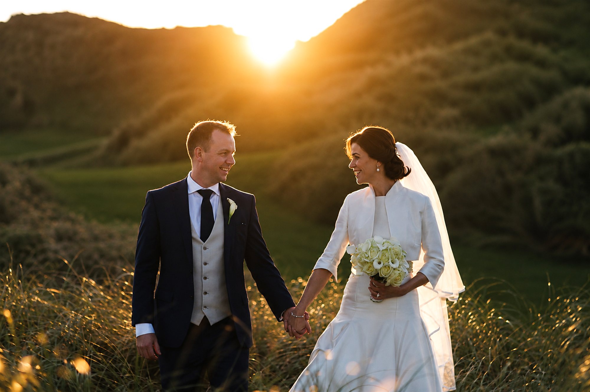 A couple walking the dunes at sunset