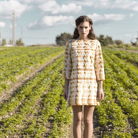 A sixties-style patterned shift dress worn barefoot in a green field