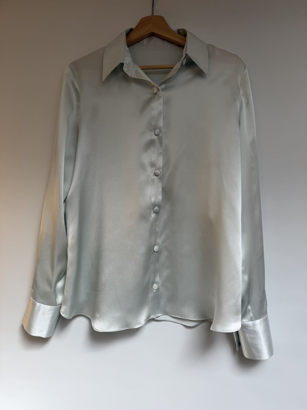 The silver-grey satin shirt laid flat, showing the cuffs
