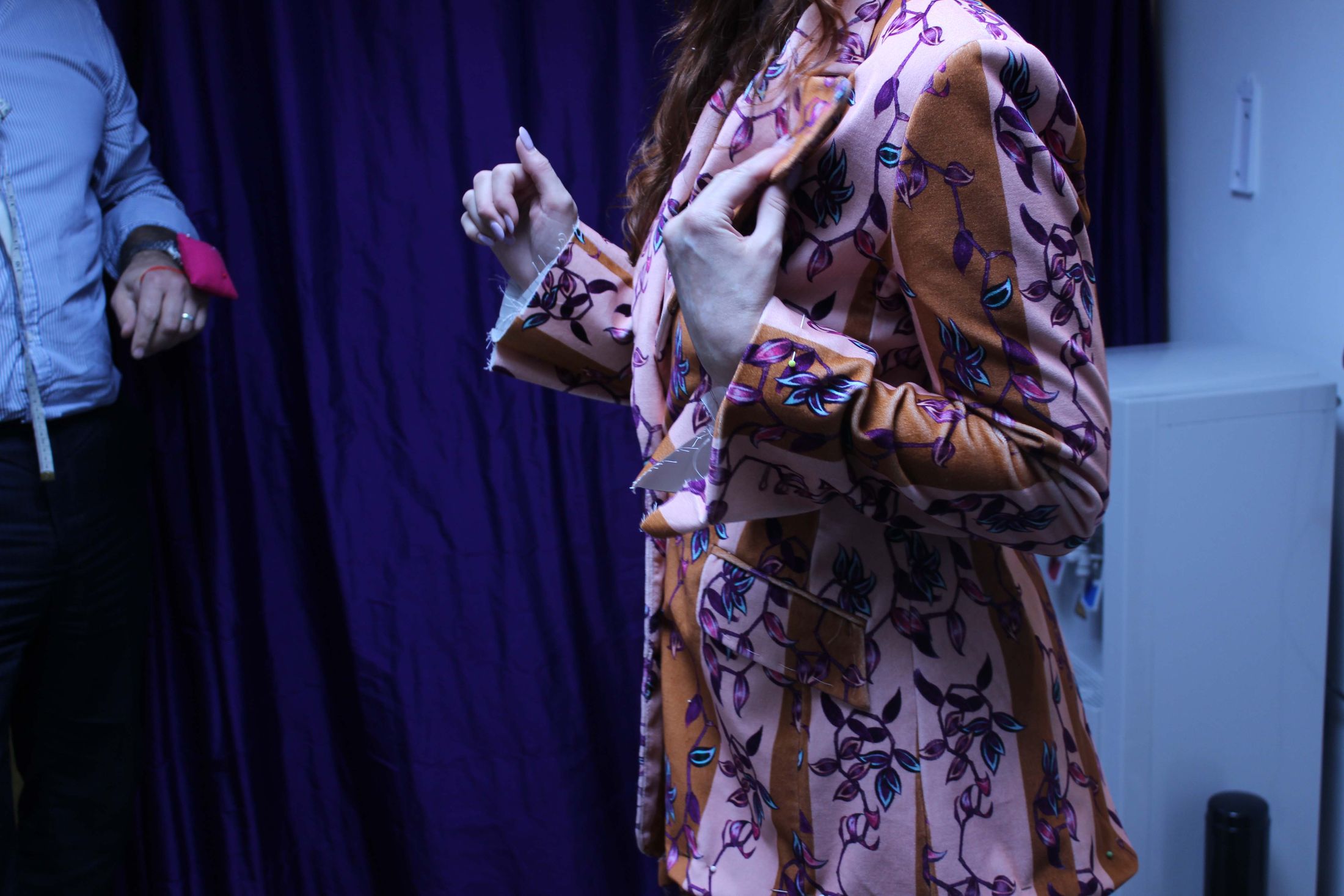 A jacket pinned during a fitting at the Orhan studio